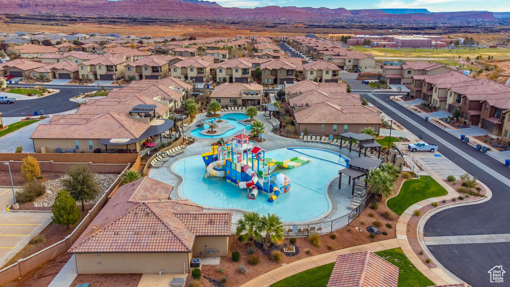 Aerial view of residential area featuring a mountain backdrop and a pool