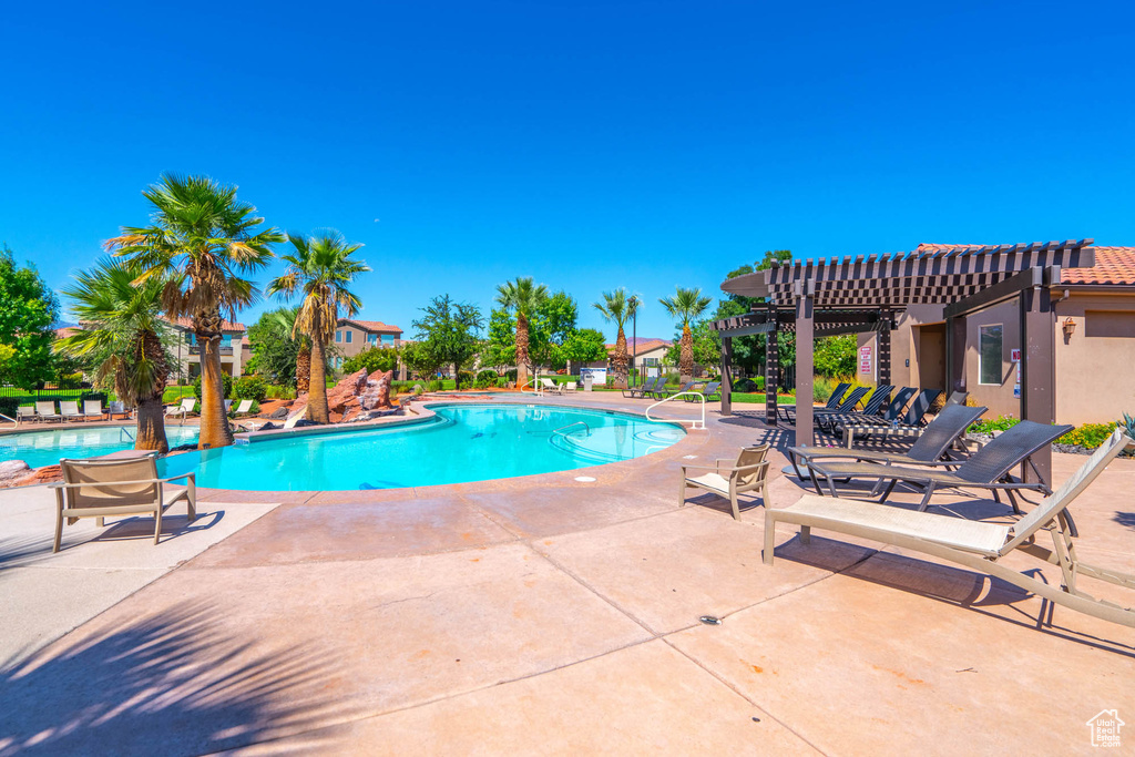 Community pool featuring a pergola and a patio