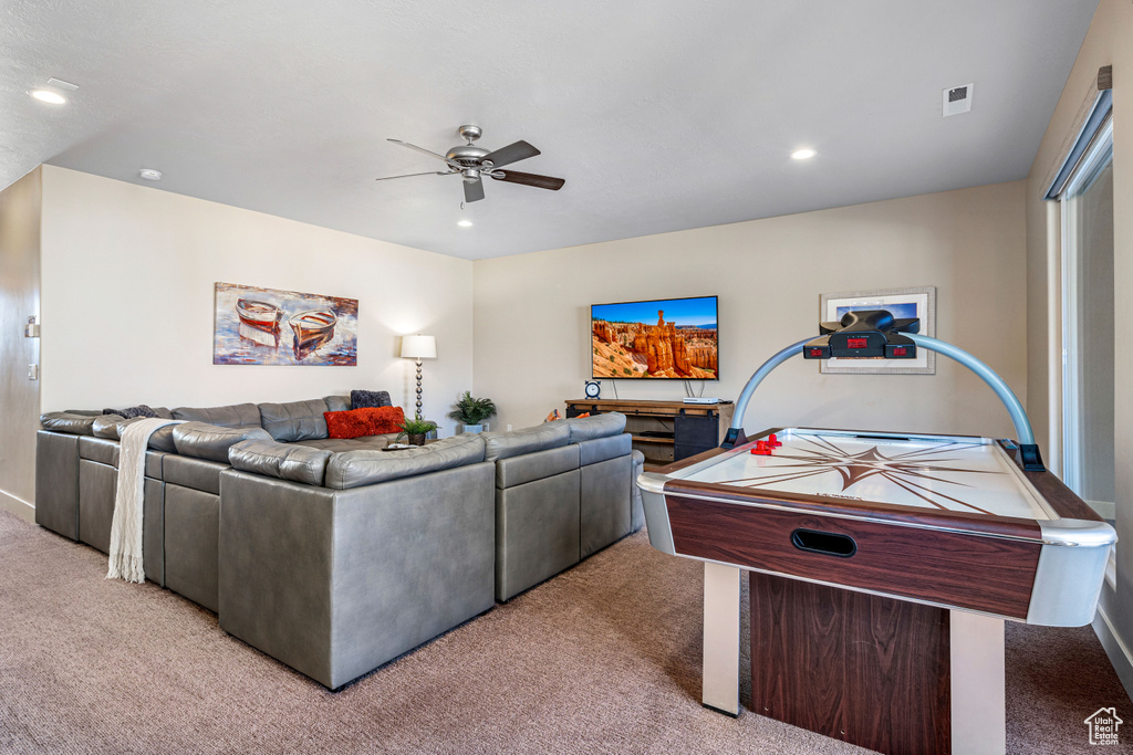 Living area featuring light colored carpet, a ceiling fan, recessed lighting, and baseboards