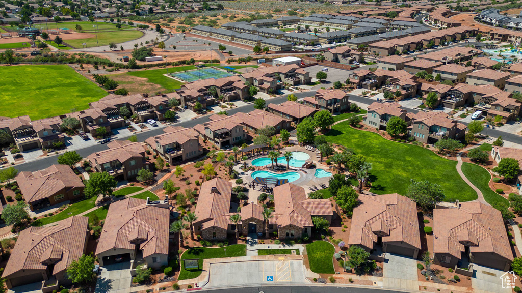 Aerial view of property and surrounding area with a pool and nearby suburban area