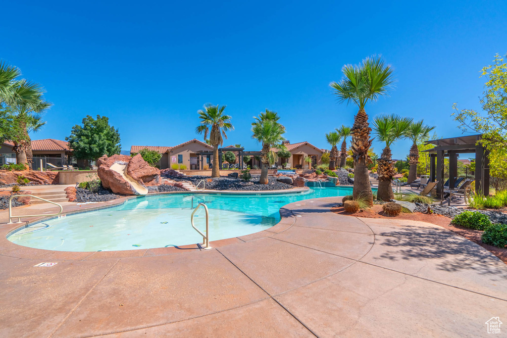 Community pool featuring a patio area and a water slide