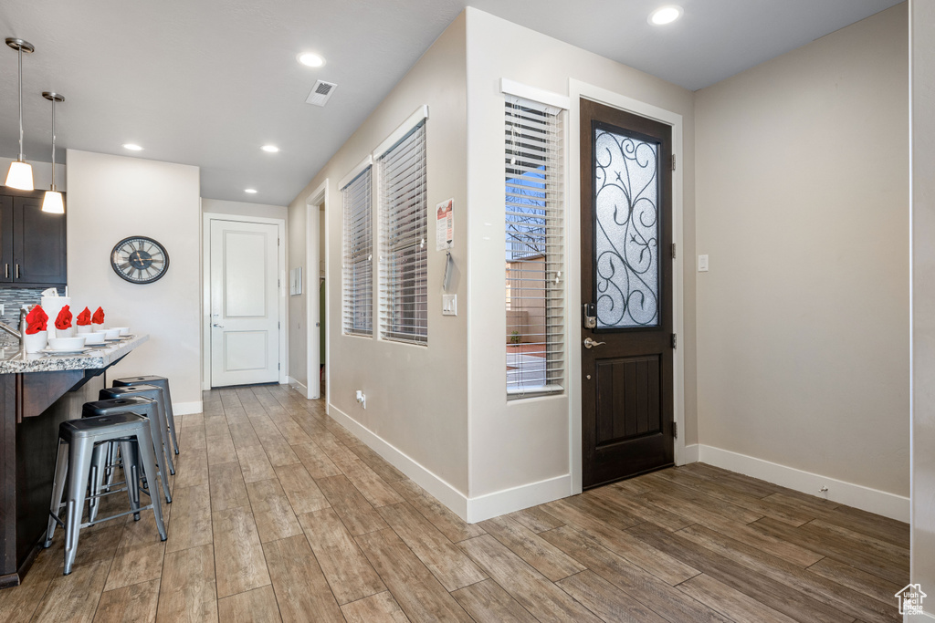 Foyer entrance with light wood finished floors, baseboards, and recessed lighting
