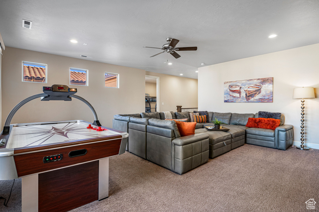Carpeted living room featuring ceiling fan and recessed lighting