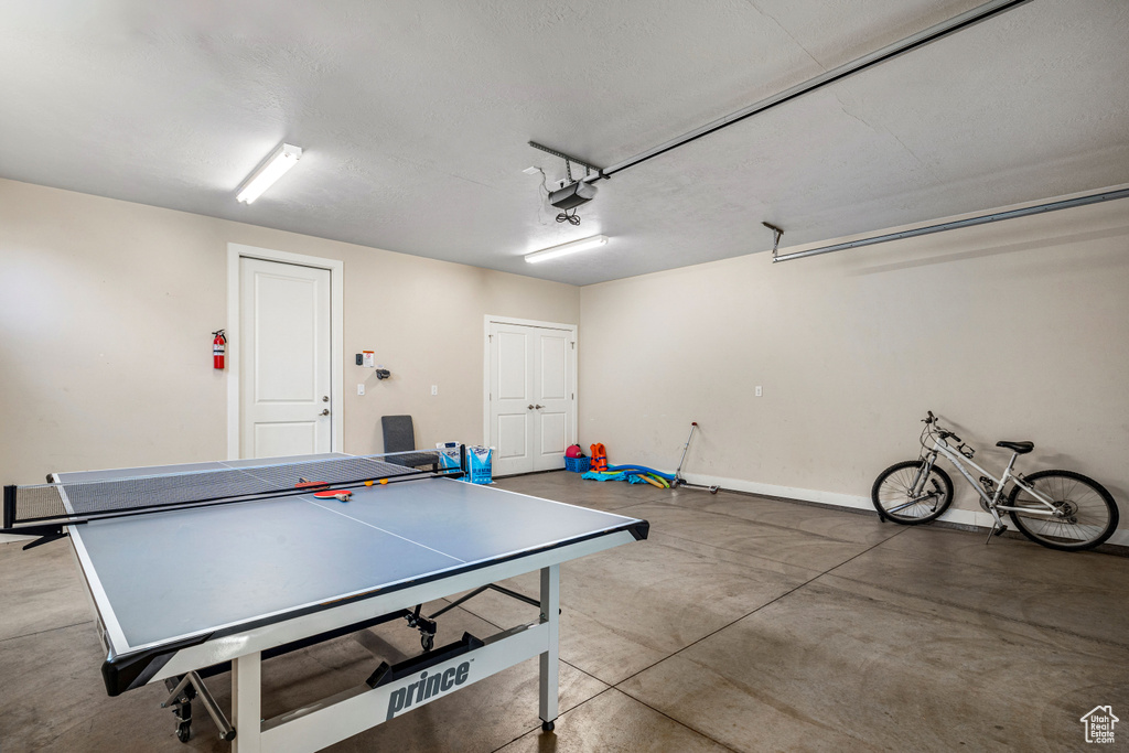Recreation room featuring a garage, concrete flooring, and baseboards
