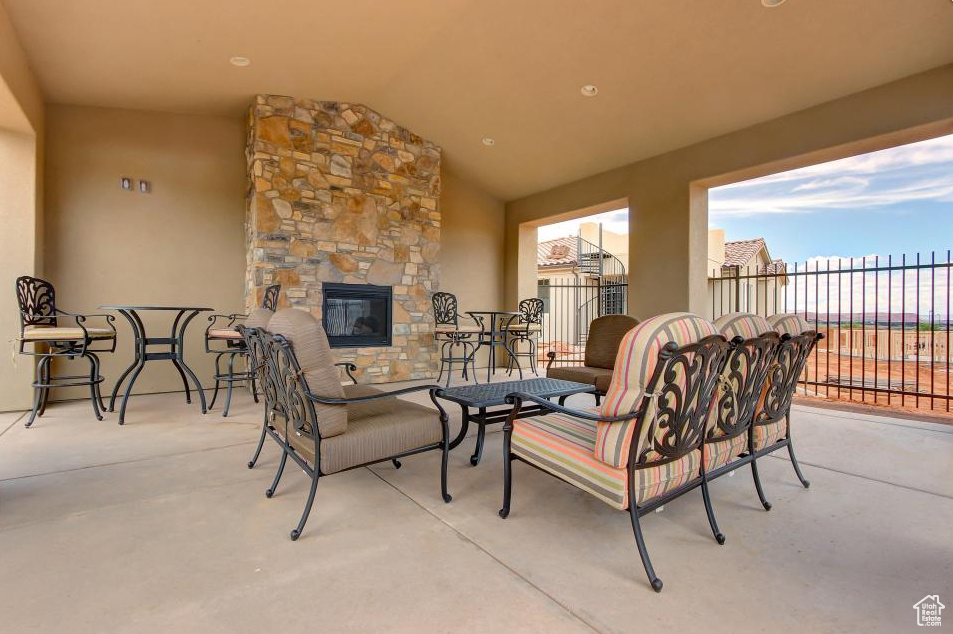 View of patio with an outdoor stone fireplace