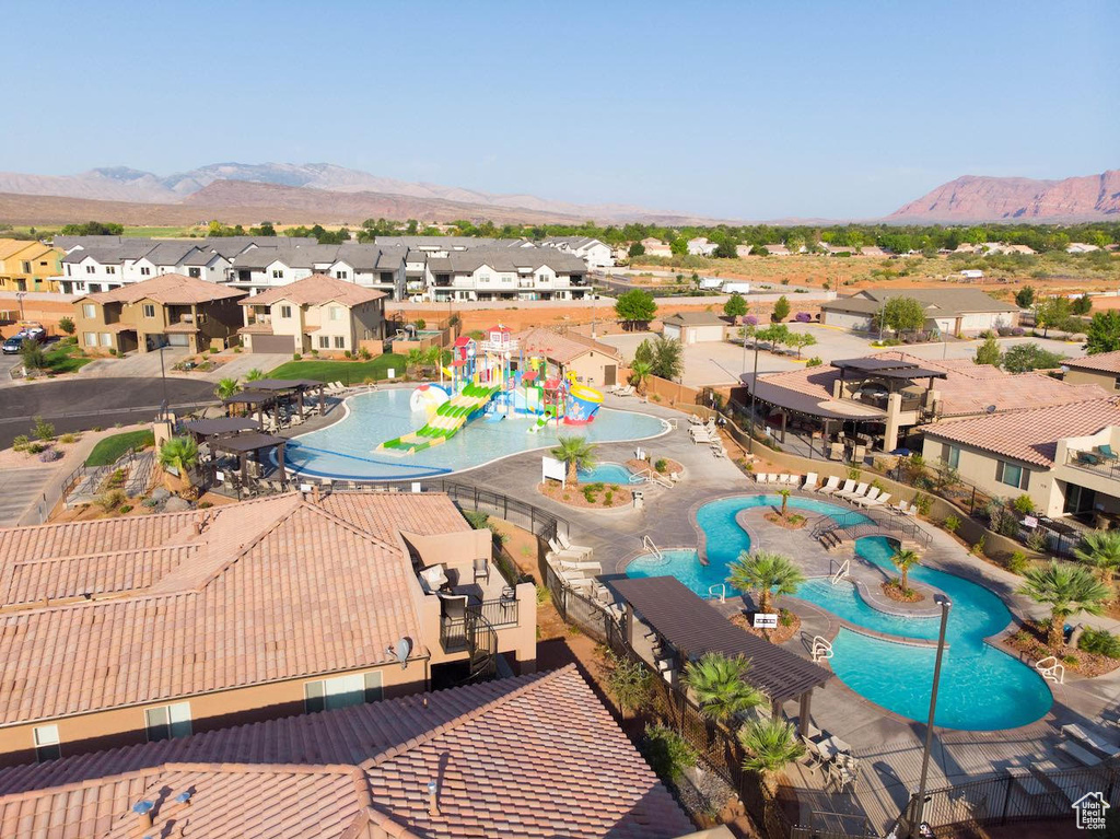 Aerial perspective of suburban area with a pool area and a mountainous background