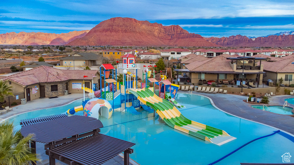 Community pool featuring a water play area, a residential view, and a mountain view