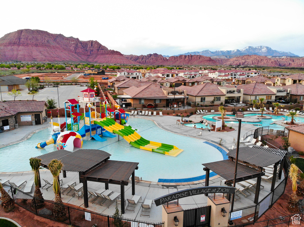 Community pool with a water play area, a residential view, and a mountain view