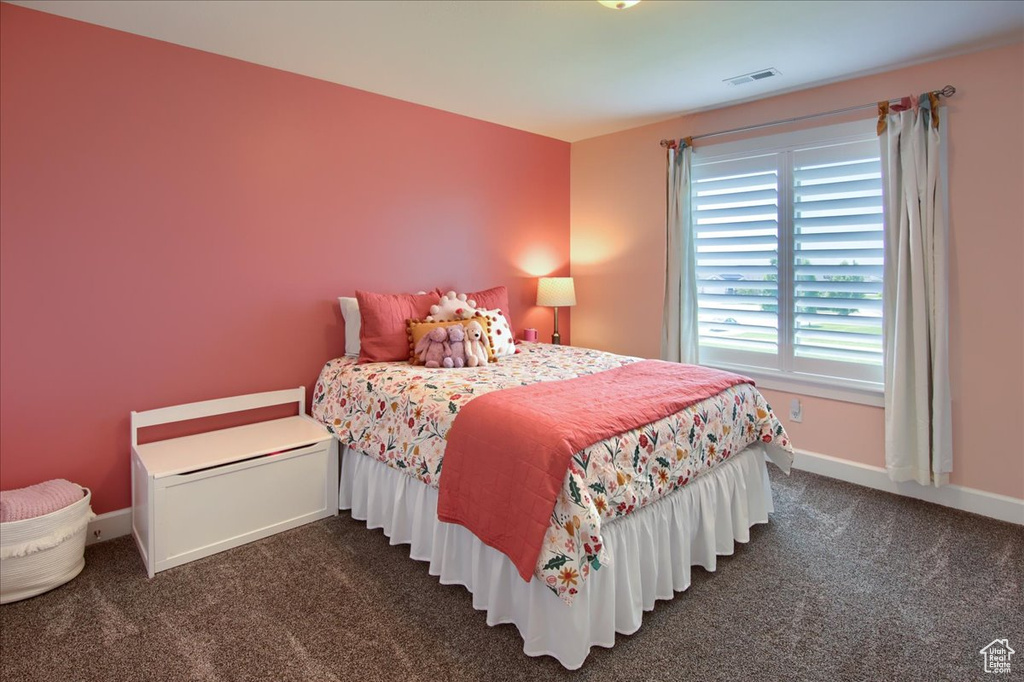 Bedroom featuring dark carpet and baseboards