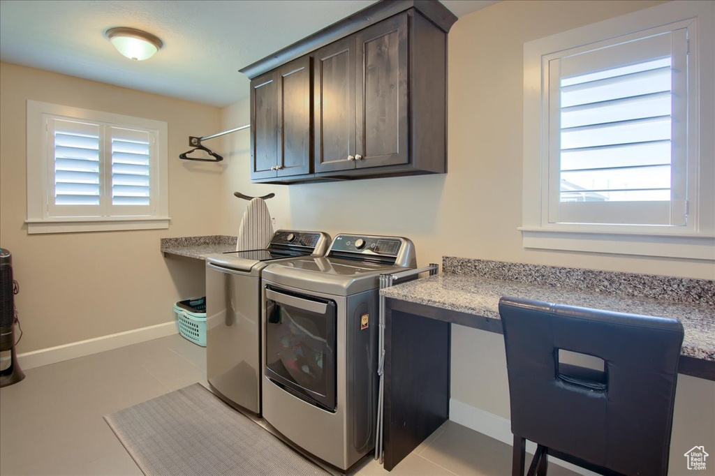 Laundry room with separate washer and dryer, cabinet space, baseboards, light tile patterned flooring, and an office area
