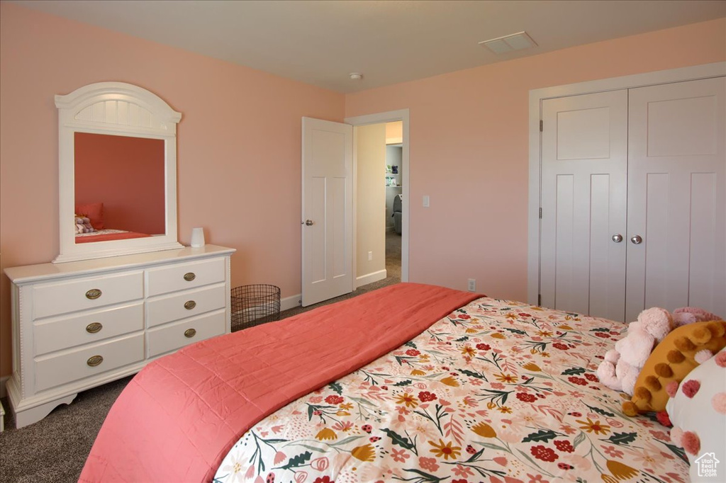 Bedroom with dark carpet and a closet