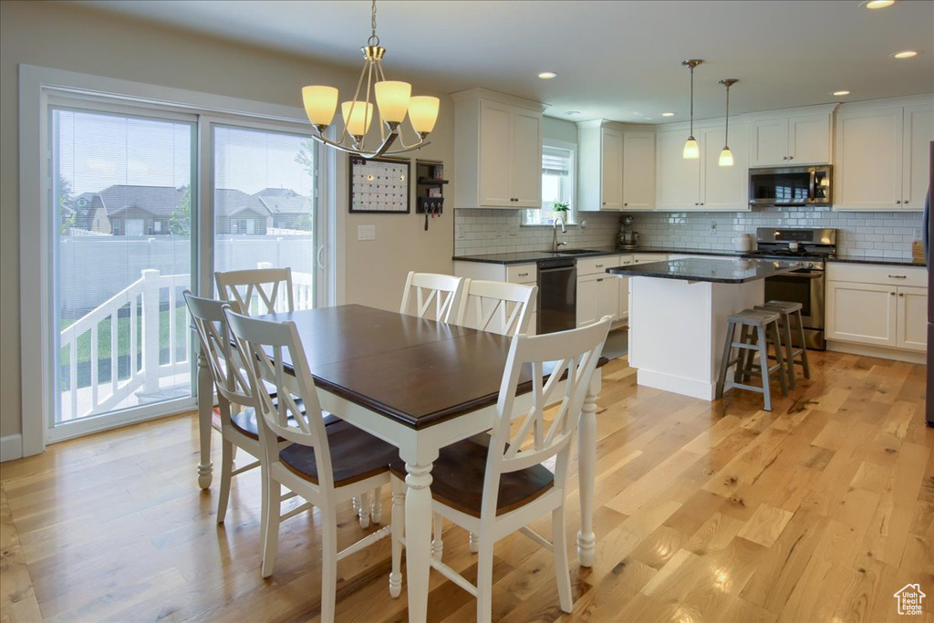 Dining space with a chandelier, light wood-type flooring, and recessed lighting