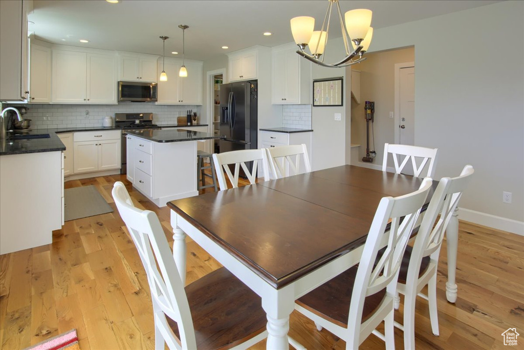 Dining space featuring a chandelier, light wood-type flooring, recessed lighting, and baseboards