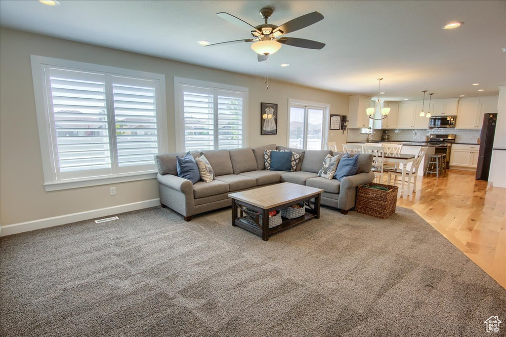 Living room featuring light colored carpet, a ceiling fan, recessed lighting, and baseboards