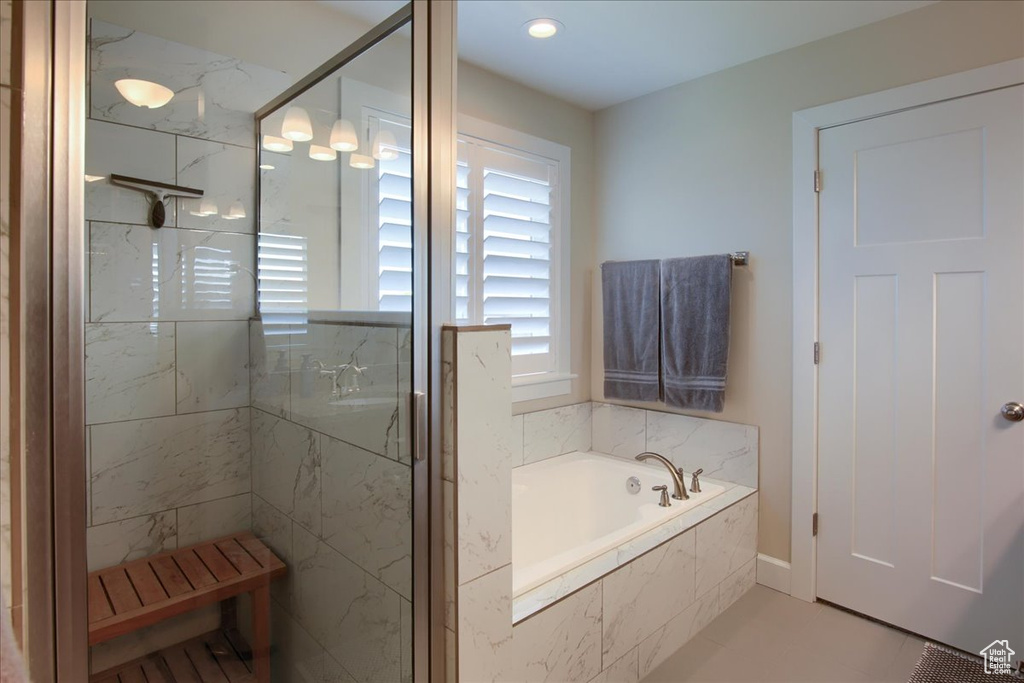 Bathroom with a bath, a marble finish shower, and tile patterned flooring