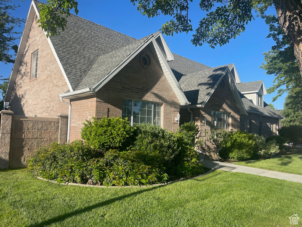View of home\\\\\\\\\\\\\\\\\\\\\\\\\\\\\\\'s exterior featuring brick siding, roof with shingles, and a lawn