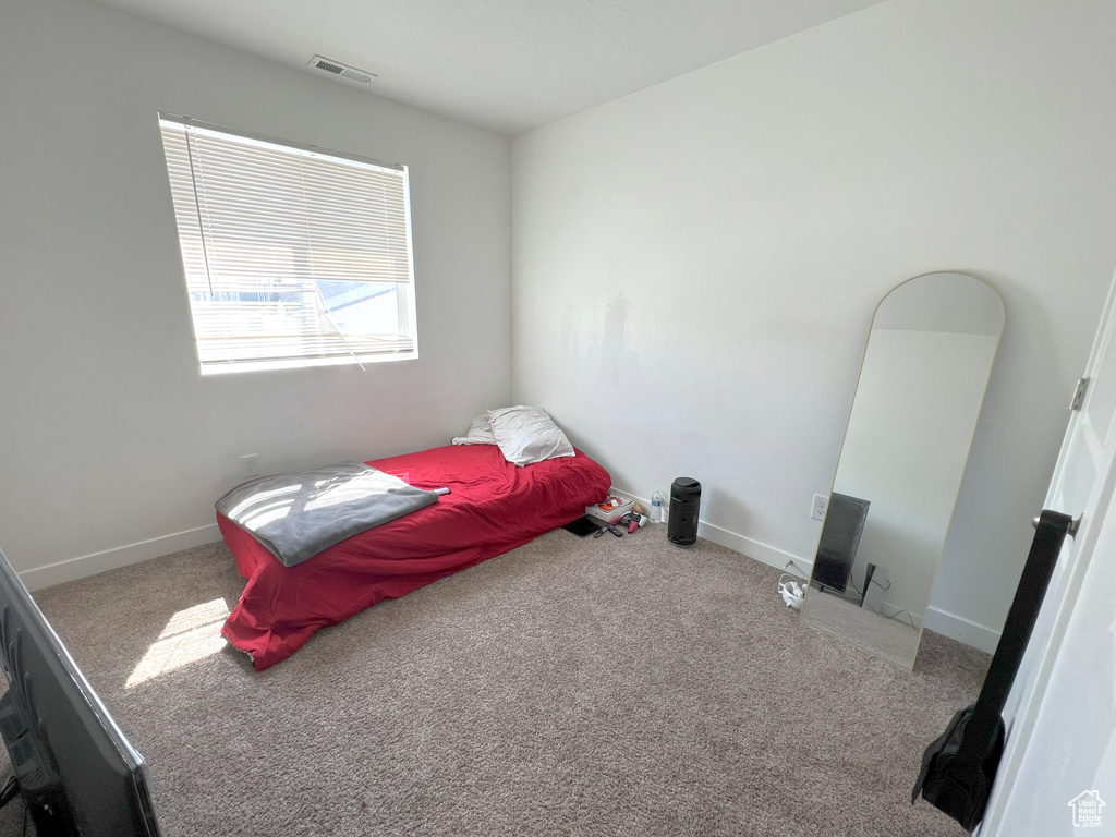 Bedroom featuring carpet and baseboards