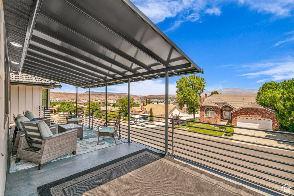 View of patio with a balcony, a residential view, and a mountain view