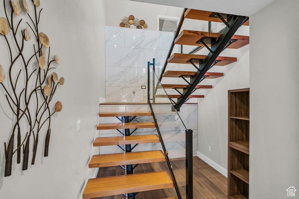 Staircase featuring wood finished floors and baseboards