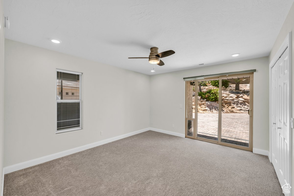 Carpeted empty room featuring a ceiling fan, baseboards, and recessed lighting