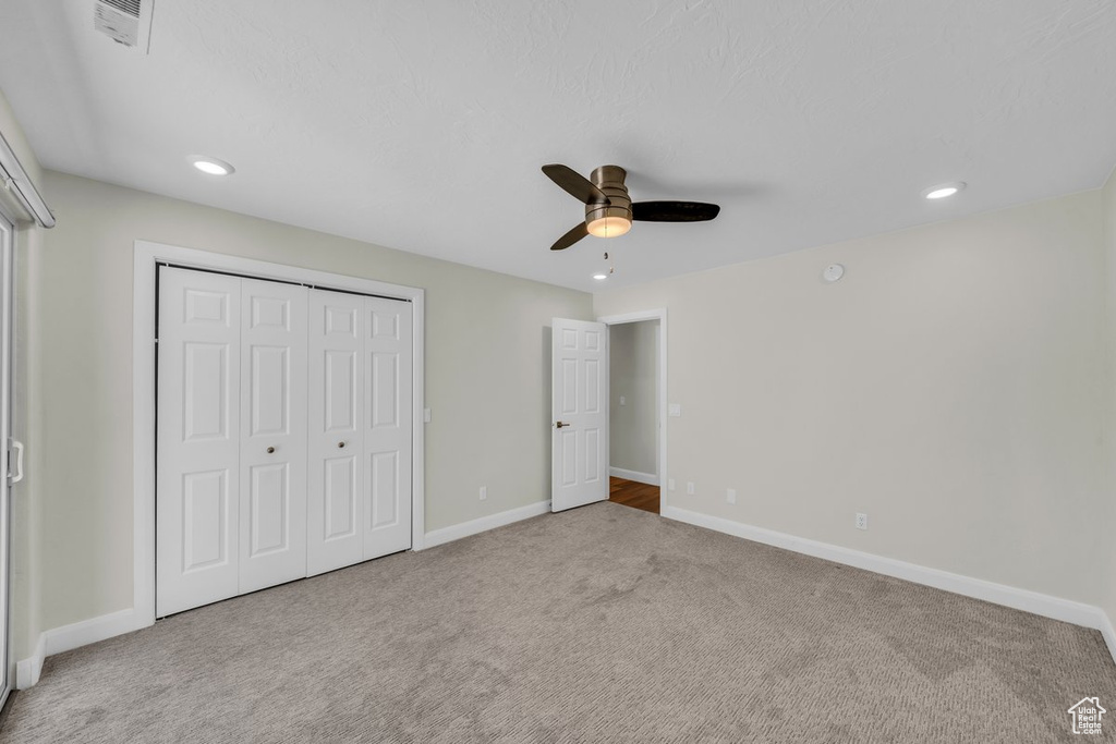 Unfurnished bedroom featuring carpet flooring, baseboards, a closet, recessed lighting, and ceiling fan