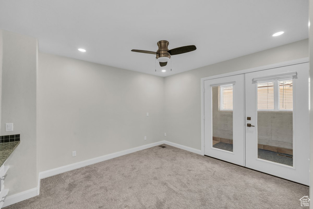 Carpeted empty room featuring french doors, ceiling fan, baseboards, and recessed lighting