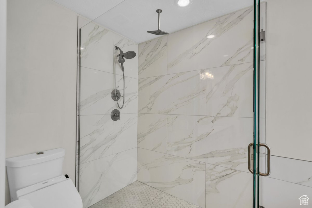 Bathroom with a marble finish shower and toilet