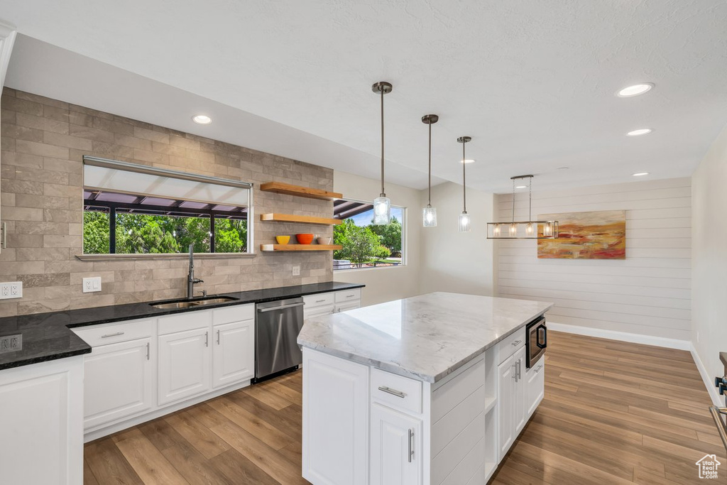 Kitchen featuring dishwasher, a sink, dark stone countertops, backsplash, and recessed lighting