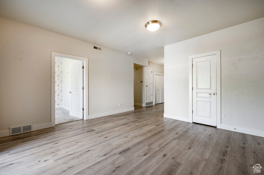 Empty room with light wood-type flooring and baseboards