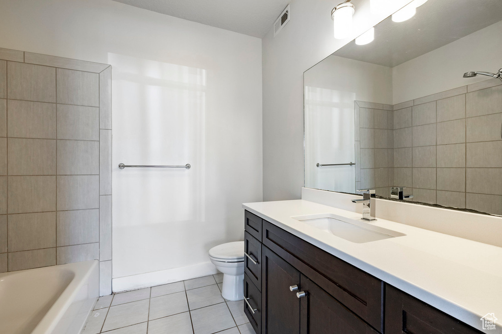 Bathroom with vanity, tile patterned floors, toilet, and tub / shower combination