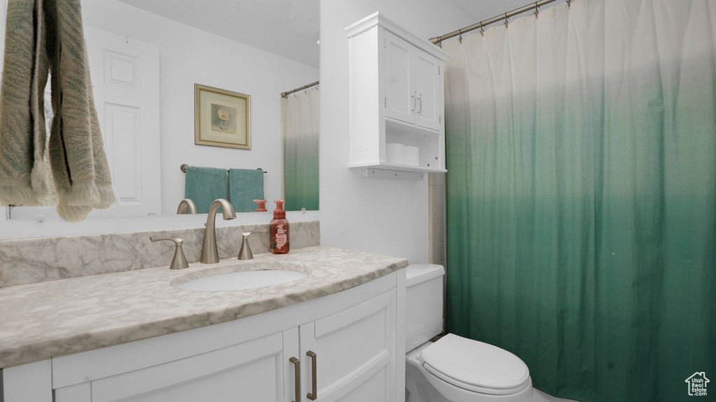 Full bath featuring vanity, toilet, and curtained shower