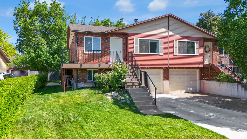 View of front facade with stairway, driveway, an attached garage, and brick siding