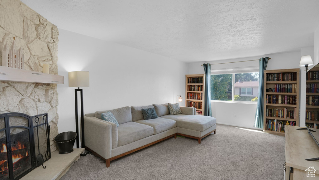 Carpeted living area with a textured ceiling and a fireplace