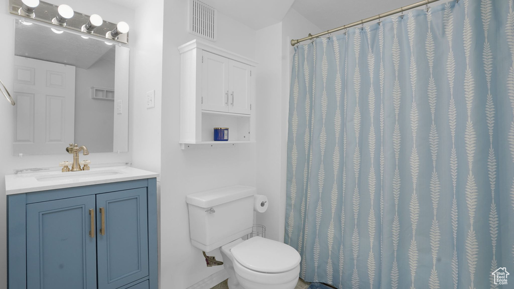 Full bath with vanity, toilet, and a shower with shower curtain
