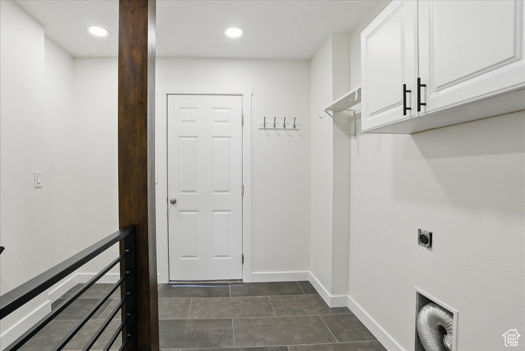 Laundry room with cabinet space, hookup for an electric dryer, dark tile patterned flooring, baseboards, and recessed lighting