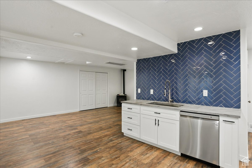 Kitchen with stainless steel dishwasher, a sink, tasteful backsplash, white cabinetry, and dark wood finished floors
