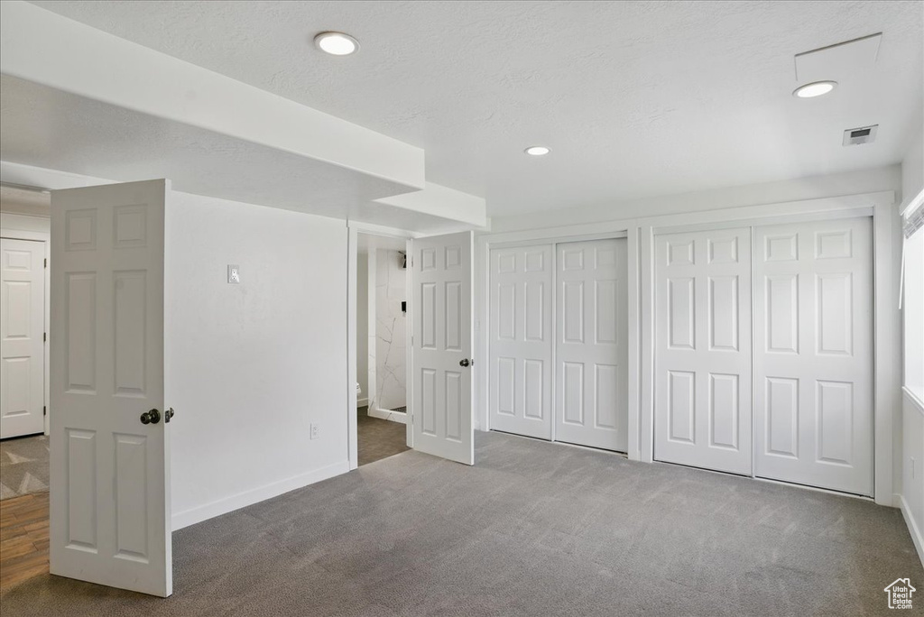 Unfurnished bedroom with two closets, carpet floors, recessed lighting, and baseboards