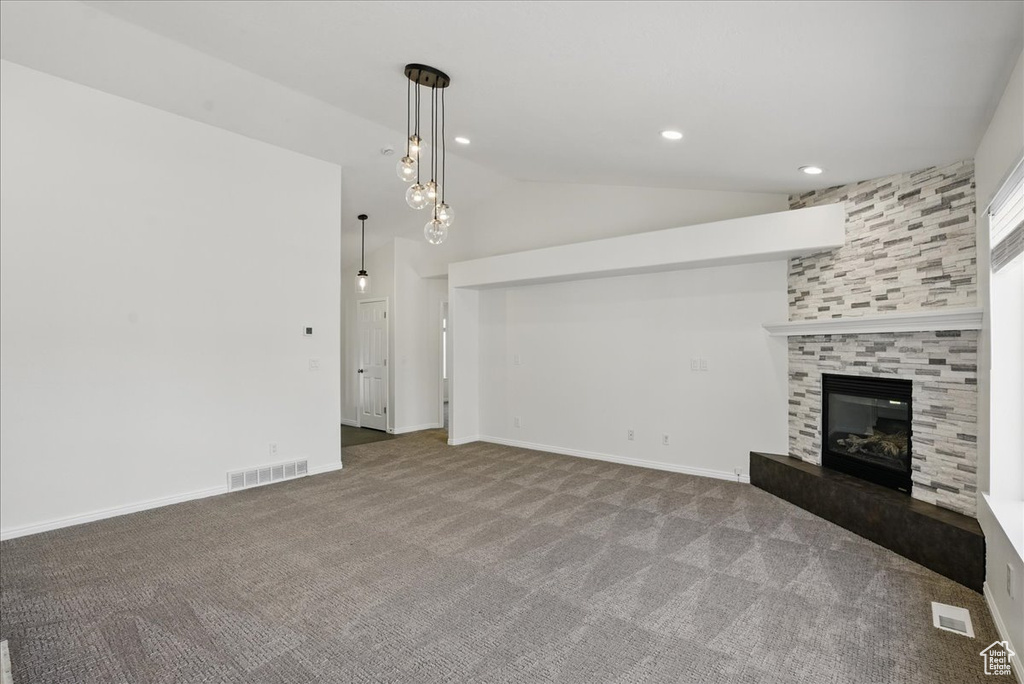 Unfurnished living room with lofted ceiling, carpet, a tile fireplace, recessed lighting, and baseboards