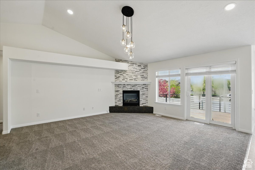 Unfurnished living room with lofted ceiling, carpet flooring, a tile fireplace, recessed lighting, and baseboards