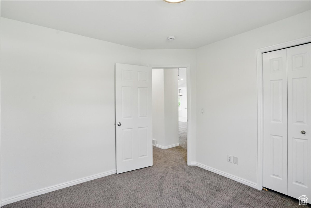 Unfurnished bedroom featuring carpet floors, a closet, and baseboards
