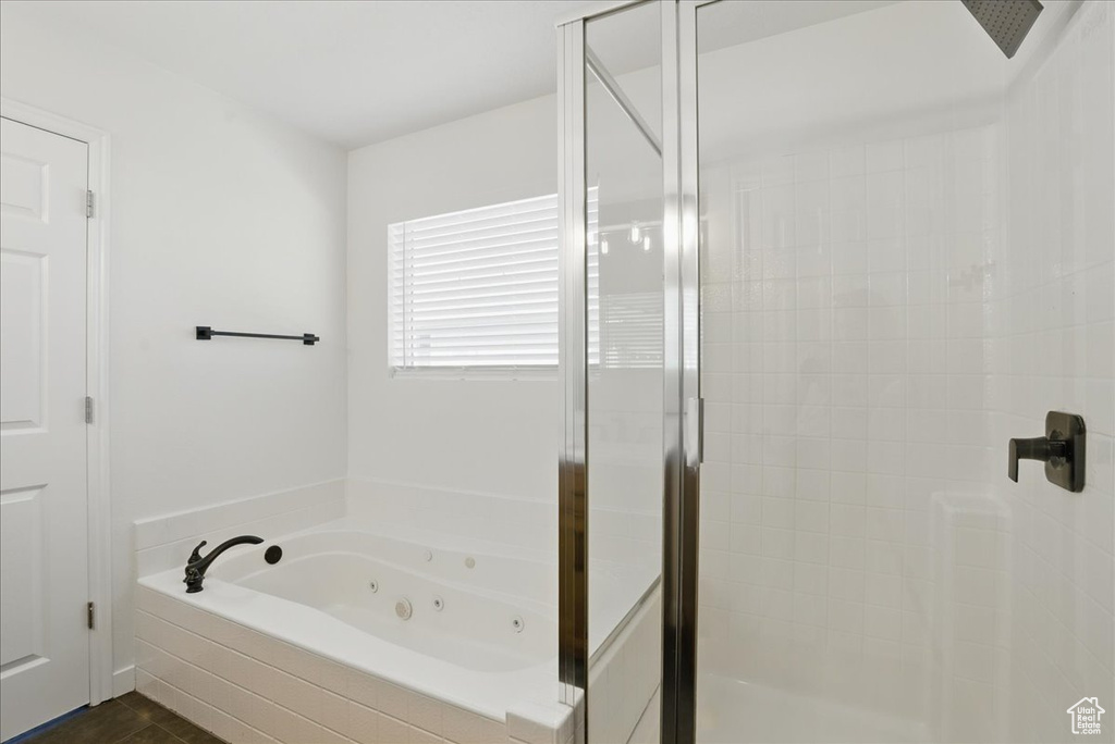 Bathroom featuring a stall shower and a tub with jets