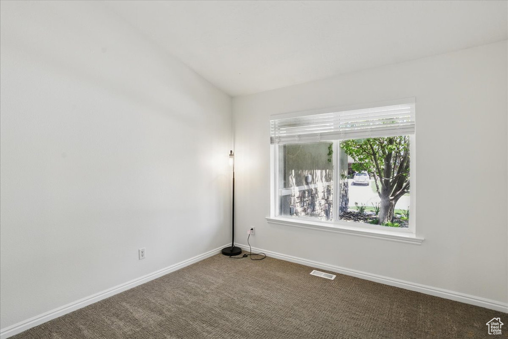 Carpeted empty room featuring baseboards