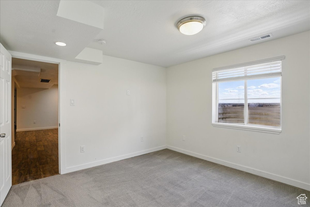 Unfurnished room featuring carpet, baseboards, and a smoke detector
