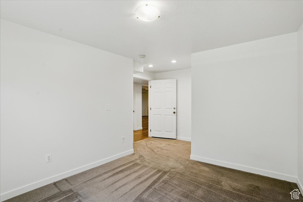 Unfurnished room featuring light colored carpet, baseboards, and recessed lighting