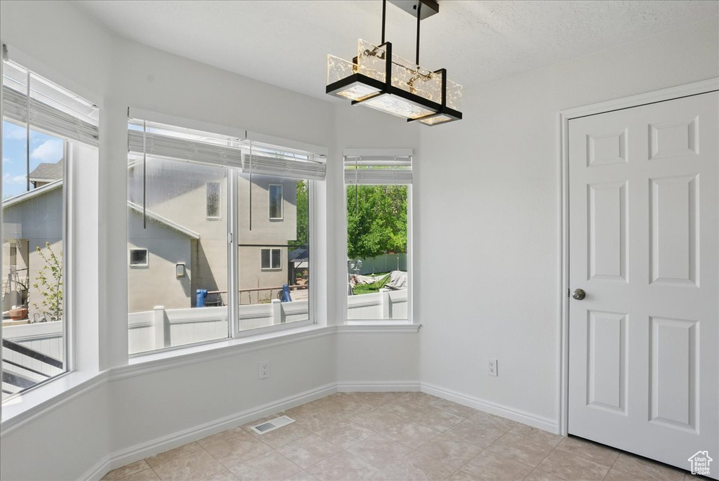 Unfurnished dining area featuring tile patterned floors and baseboards