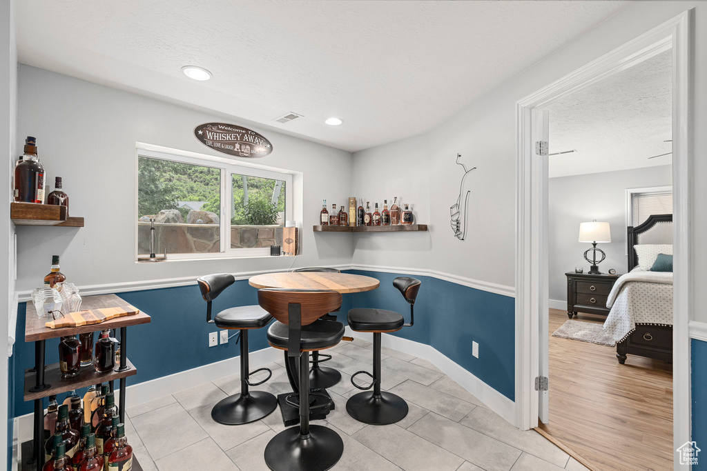 Dining room with a dry bar, baseboards, recessed lighting, and tile patterned flooring
