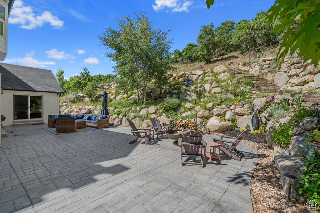 View of patio featuring an outdoor living space with a fire pit