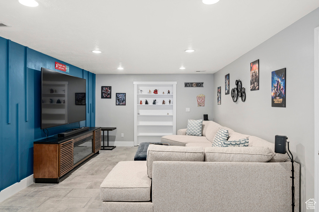 Living room featuring baseboards, recessed lighting, and built in features