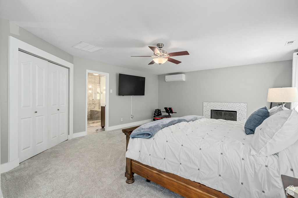 Bedroom featuring a wall mounted air conditioner, carpet floors, baseboards, ceiling fan, and a closet