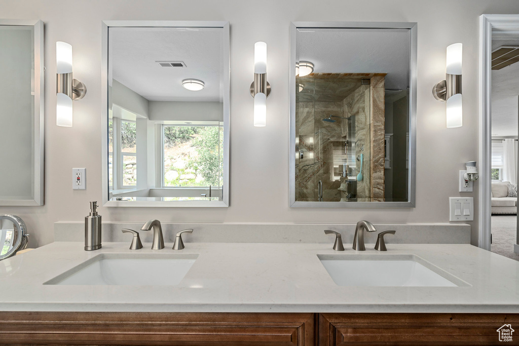 Bathroom featuring a stall shower and double vanity